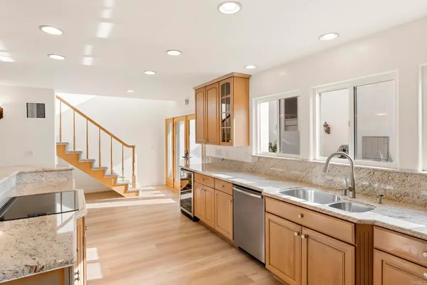 a kitchen with a sink chandelier and wooden floor