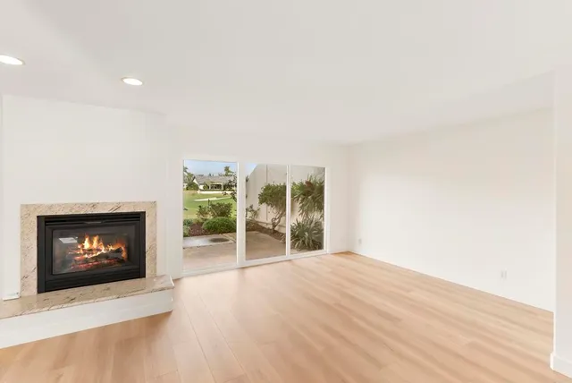an empty room with wooden floor and fireplace