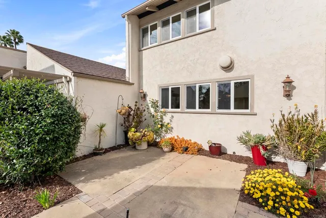 a lot of flowers in front of a white house