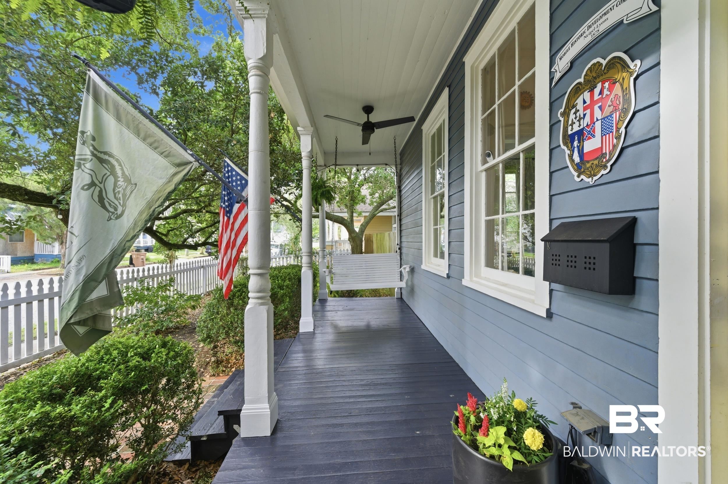 350 Charles Street Mobile, AL 36604 - Photo 4 of 52 Covered front porch with dark-stained wood flooring and white support columns