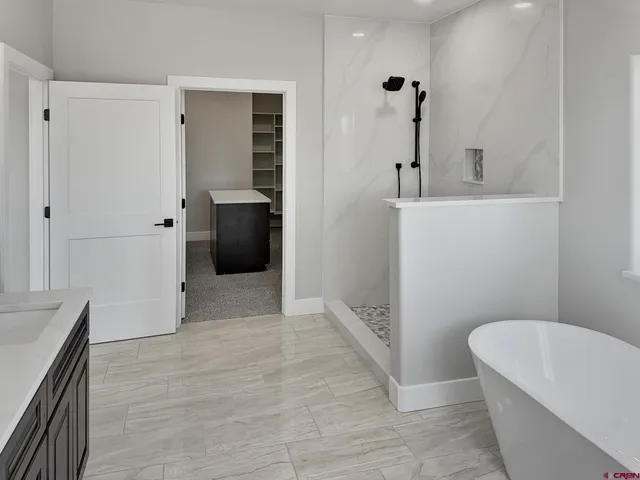 a bathroom with a tub a toilet a sink and mirror