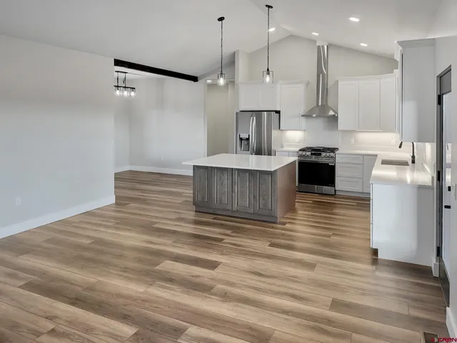 a kitchen with kitchen island a stove a refrigerator and a counter top space