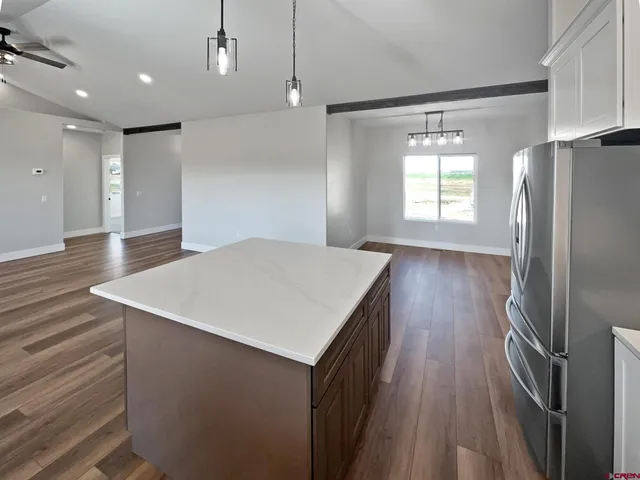 a kitchen with kitchen island a counter top space wooden floor and stainless steel appliances
