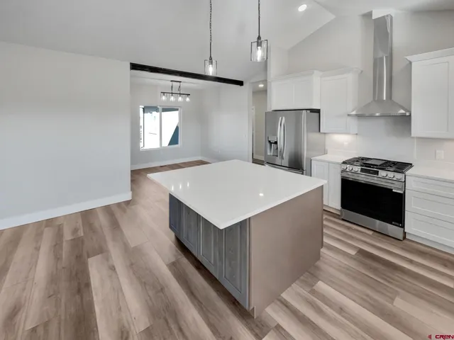 a kitchen with kitchen island a sink dishwasher stove and oven with wooden floor