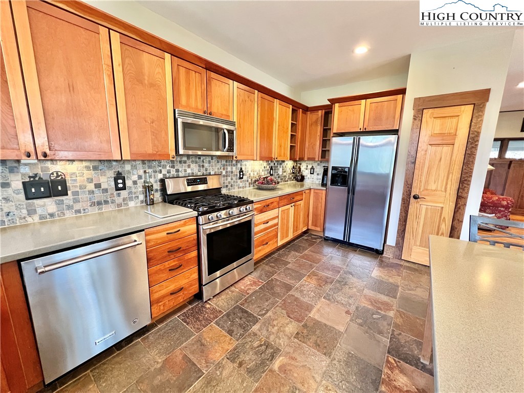 259 The Settlement Boone, NC 28607 - Photo 20 of 50 a kitchen with stainless steel appliances granite countertop a stove top oven sink and a refrigerator