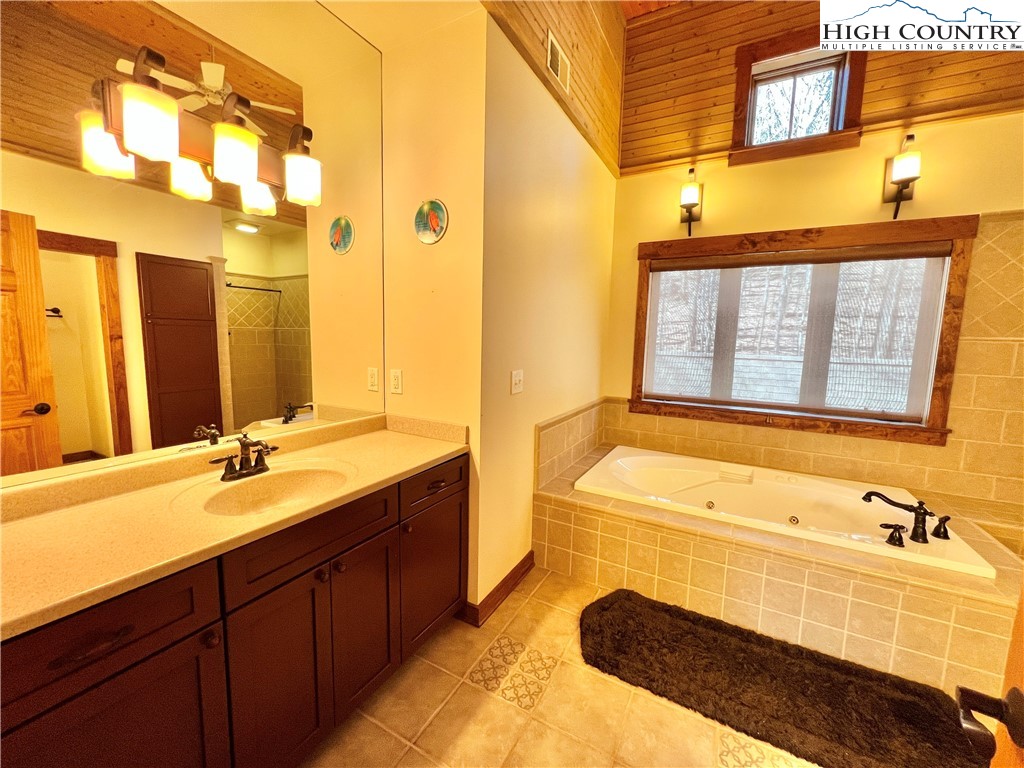 259 The Settlement Boone, NC 28607 - Photo 31 of 50 a bathroom with a tub sink and mirror