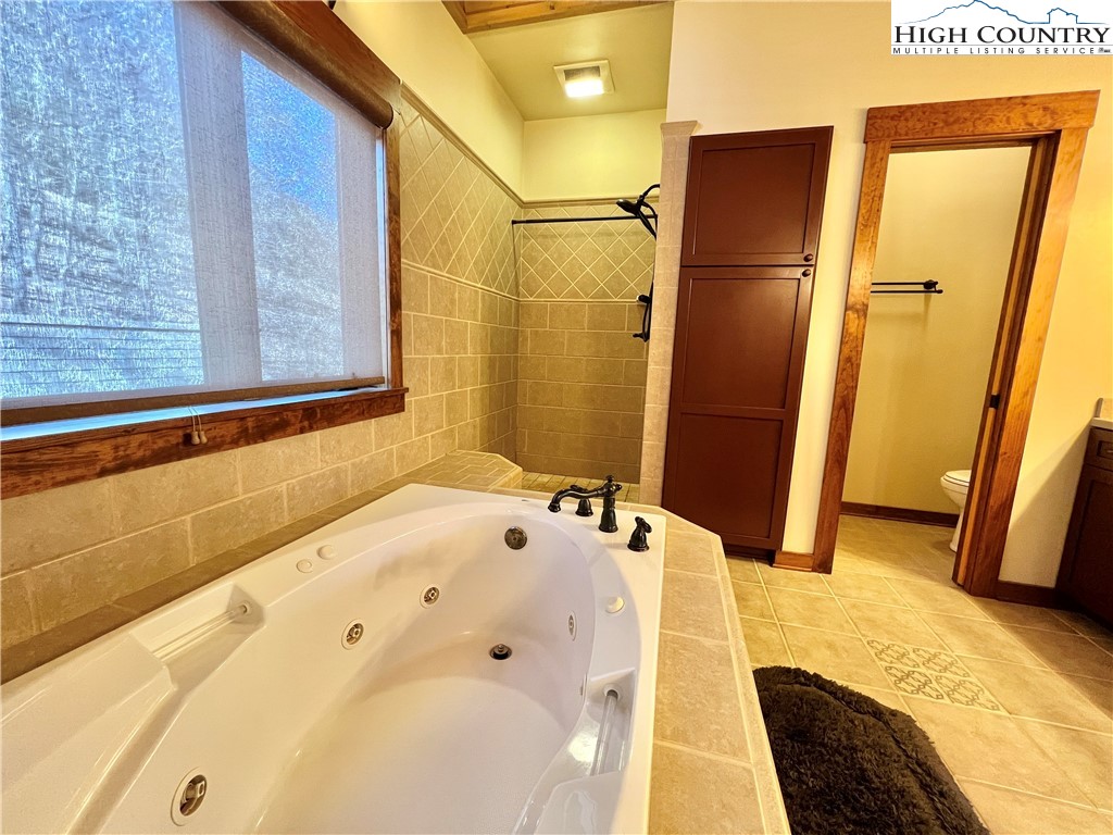 259 The Settlement Boone, NC 28607 - Photo 32 of 50 a bathroom with a tub sink and a mirror