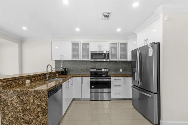 a kitchen with stainless steel appliances granite countertop a sink stove and refrigerator