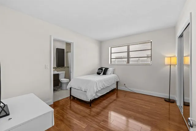 a bedroom with bed and a mirror