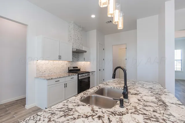 a large kitchen with a stove and a sink