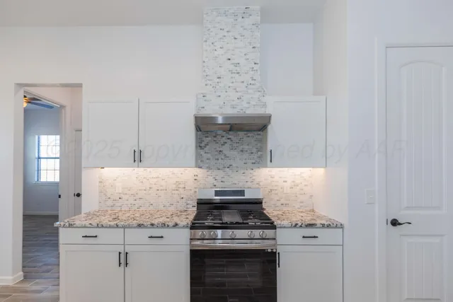 a kitchen with granite countertop a stove a sink and a granite counter tops