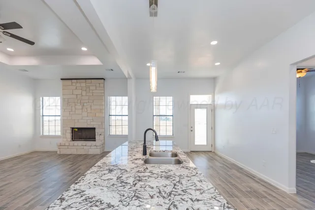 a view of a hallway with wooden floor and a chandelier
