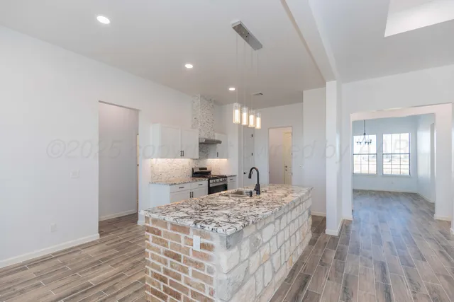 a view of a hallway with wooden floor and a chandelier