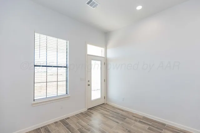 a view of an empty room with wooden floor