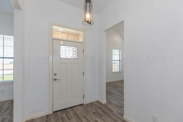 a view of an empty room with a fireplace and a window