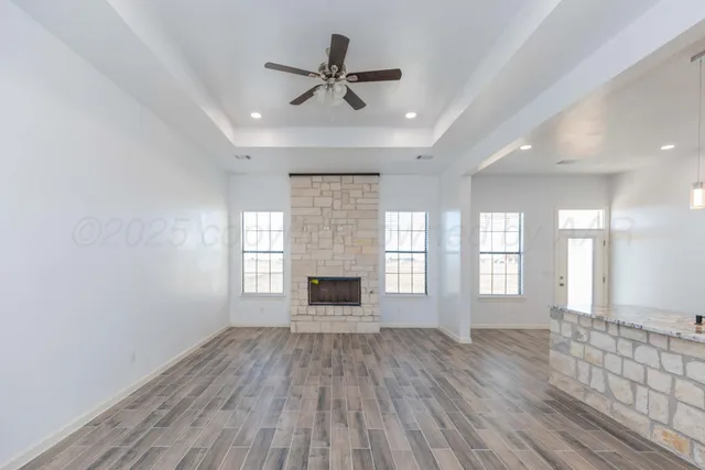 a view of an empty room with a fireplace and a window