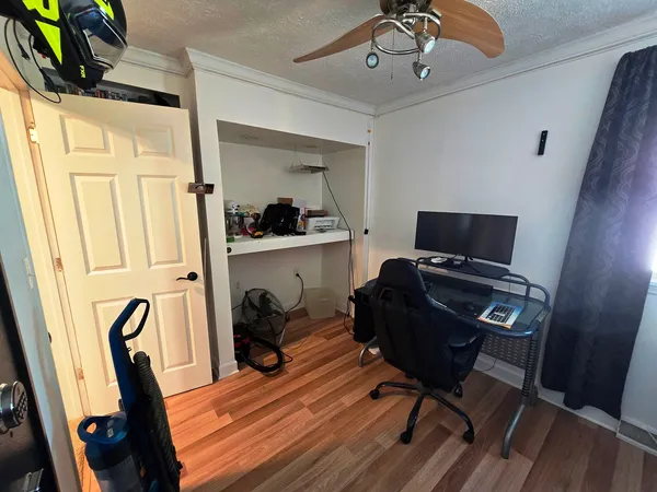a view of a workspace with furniture and a window