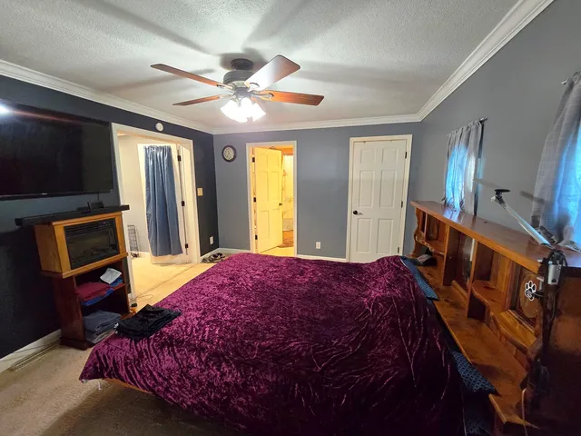 a bedroom with a bed a dresser and flat screen tv