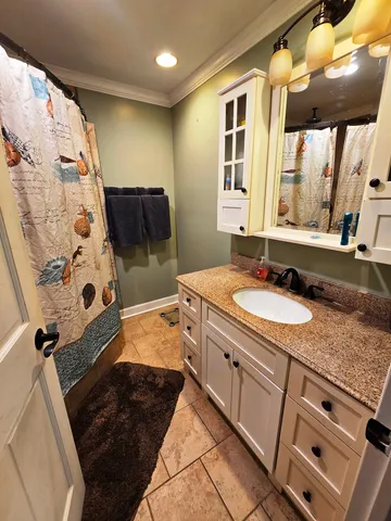 a bathroom with a granite countertop sink a vanity and shower