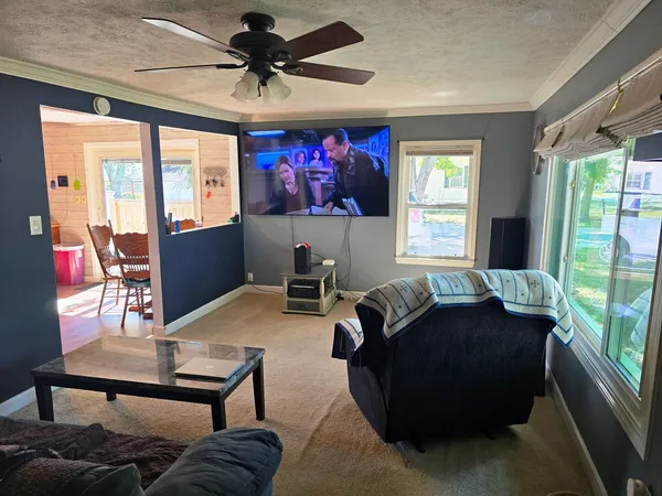 a living room with furniture a flat screen tv and a large window