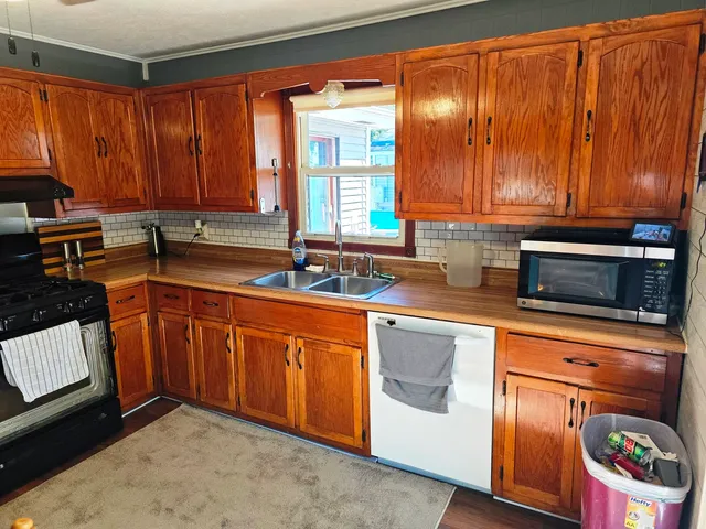 a kitchen with stainless steel appliances granite countertop a sink stove and cabinets