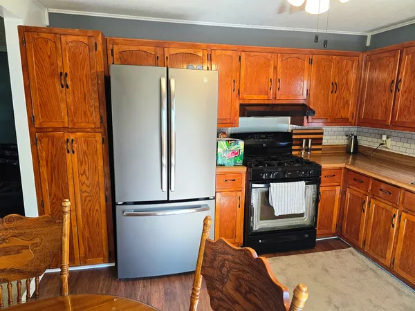 a kitchen with stainless steel appliances granite countertop a refrigerator a sink and wooden cabinets