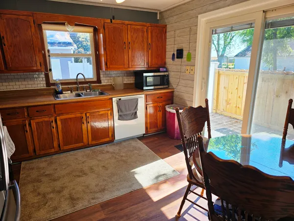 a kitchen with stainless steel appliances granite countertop wooden cabinets a stove top oven a sink and dishwasher