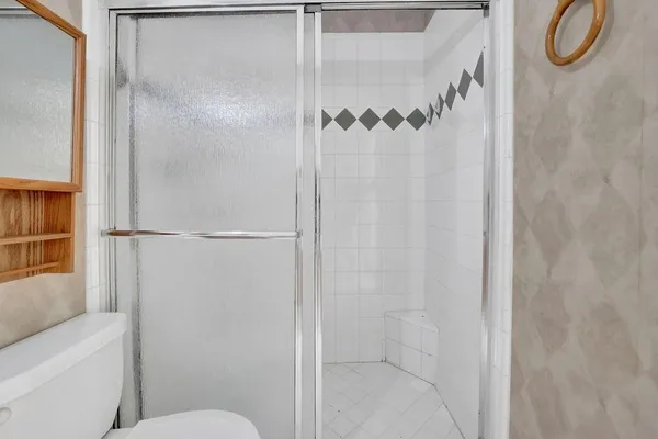 a bathroom with a granite countertop shower and a toilet