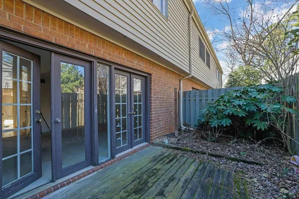 a view of backyard with potted plants and wooden fence