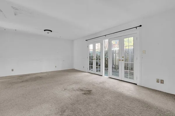 a view of an empty room with glass door and balcony