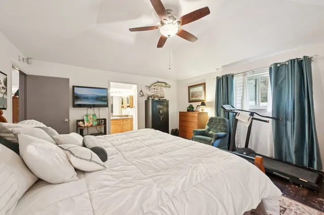 a large bedroom with a bed dresser and a large window