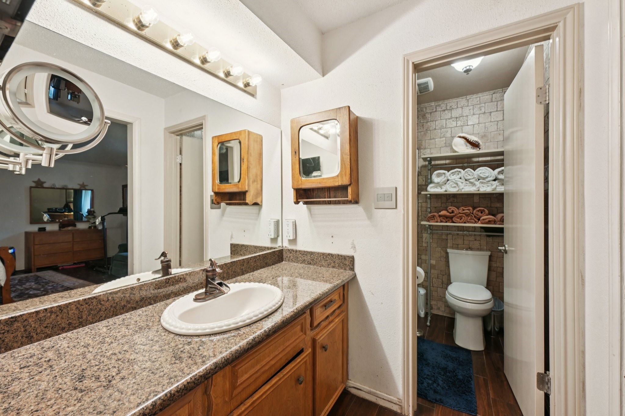 2007 Diane Street Pinehurst, TX 77362 - Photo 34 of 49 a bathroom with a granite countertop toilet a sink and a mirror