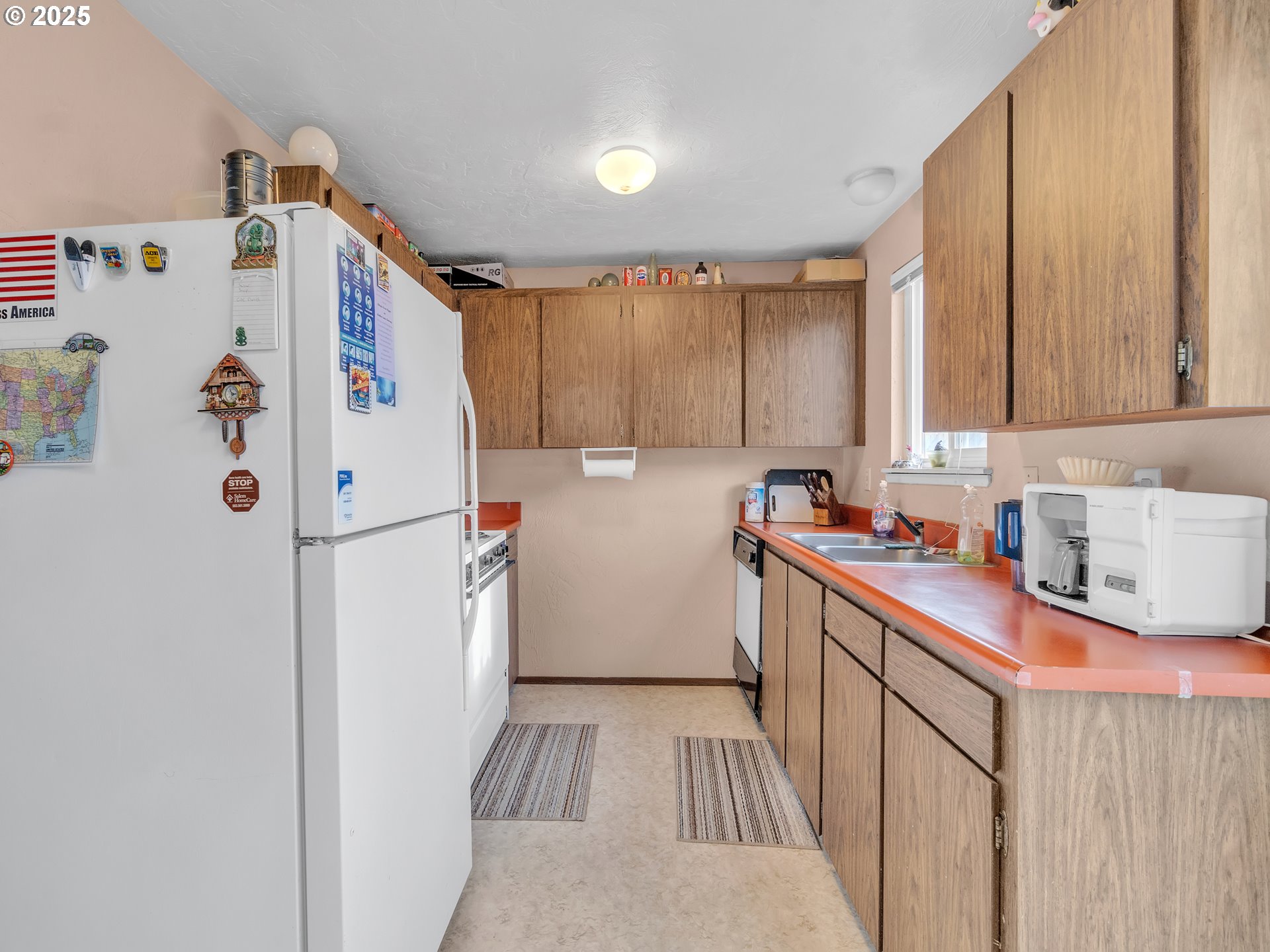 2551 Southwest Pickford Street, Unit D Corvallis, OR 97333 - Photo 8 of 25 a kitchen with a refrigerator a stove top oven a sink and dishwasher with wooden floor
