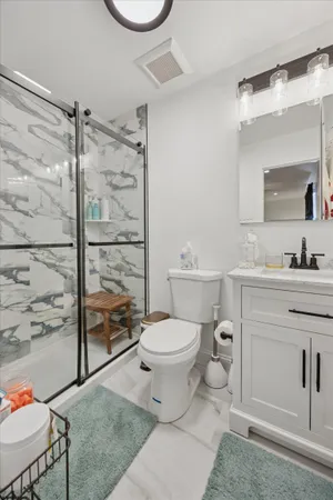 a bathroom with a sink toilet vanity and shower