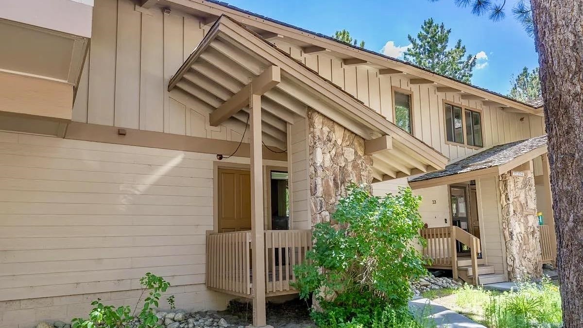 3252 Chateau Road, Unit 22 Mammoth Lakes, CA 93546 - Photo 37 of 46 Multi-level exterior featuring vertical wood siding, stone veneer accents, and multiple covered entryways