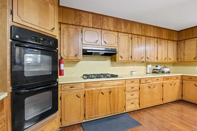 a kitchen with stainless steel appliances granite countertop a stove microwave and cabinets