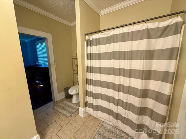 a view of an empty room with wooden floor fireplace and a window