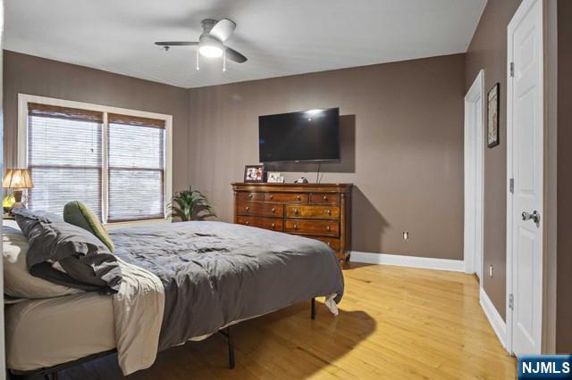 15-19 Tichenor Lane, Unit 404 Newark, NJ 07114 - Photo 11 of 22 a bedroom with a bed and a flat tv screen on dresser