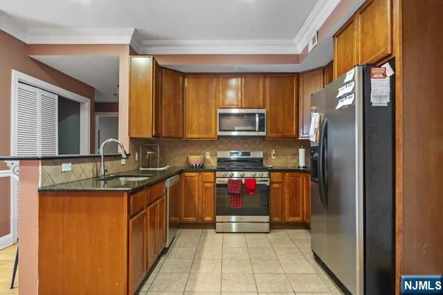 a kitchen with stainless steel appliances granite countertop a refrigerator and a sink