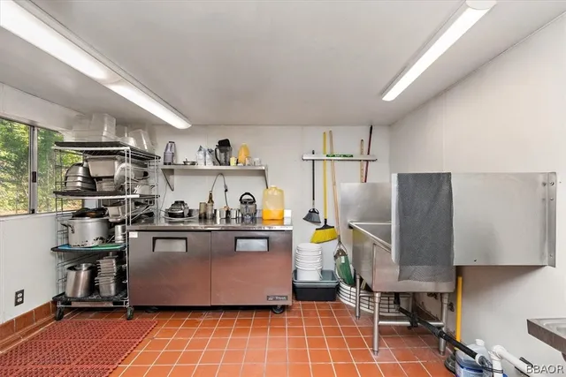 a kitchen with stainless steel appliances a sink cabinets and wooden floor
