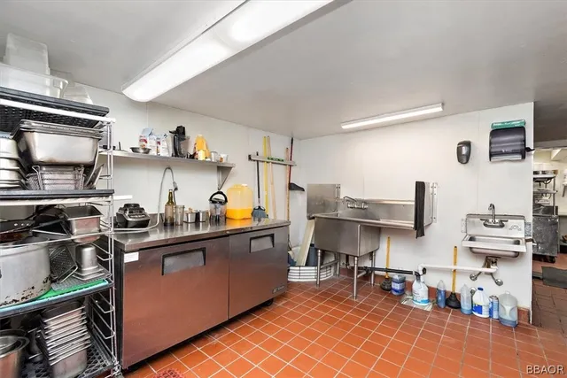 a living room with stainless steel appliances furniture a rug and a window