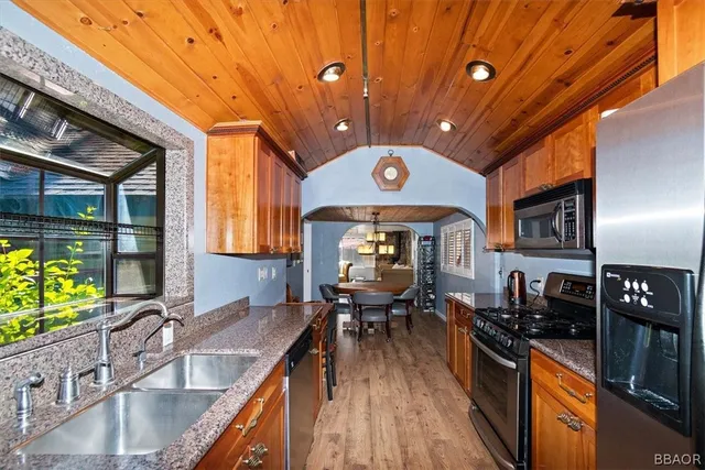 a kitchen with stainless steel appliances granite countertop a sink a stove and a refrigerator