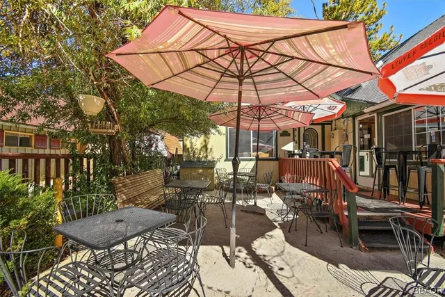a view of a patio with a table and chairs under an umbrella