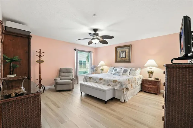 a spacious bedroom with a bed couch and a ceiling fan