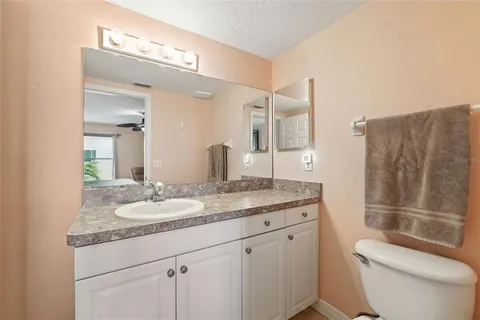 a bathroom with a granite countertop sink toilet and shower