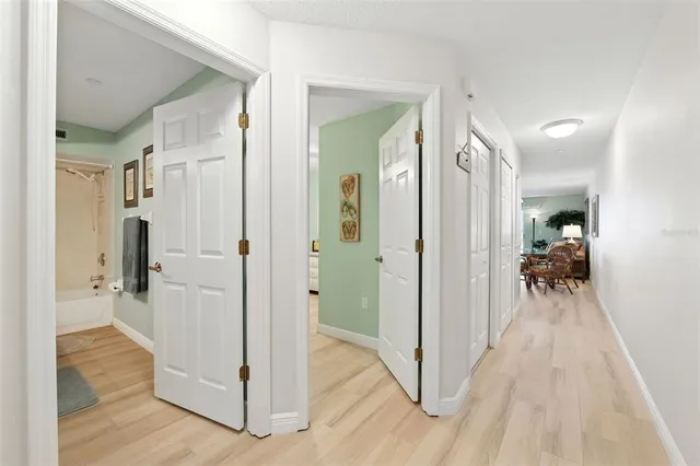 a view of a hallway with wooden floor and a living room