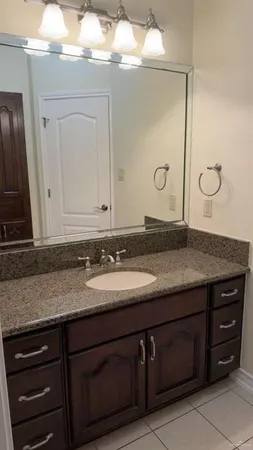 a bathroom with a granite countertop sink and a mirror