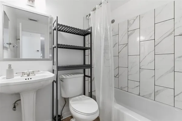 a bathroom with a sink toilet and shower