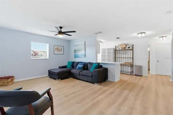 a living room with furniture and a ceiling fan