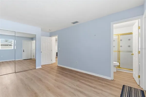 an empty room with wooden floor and mirror
